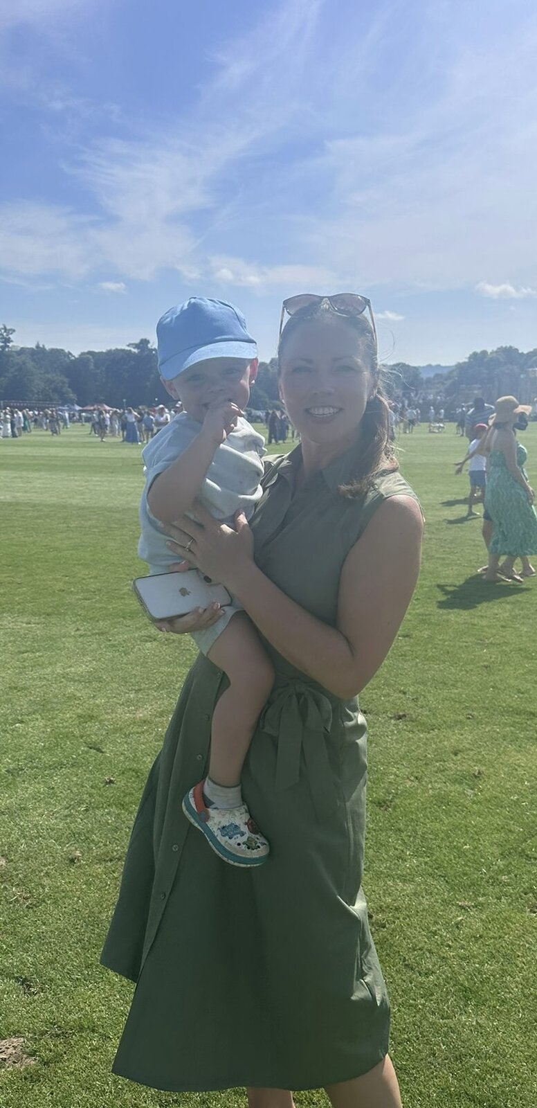 Niamh smiling outdoors while holding a young child