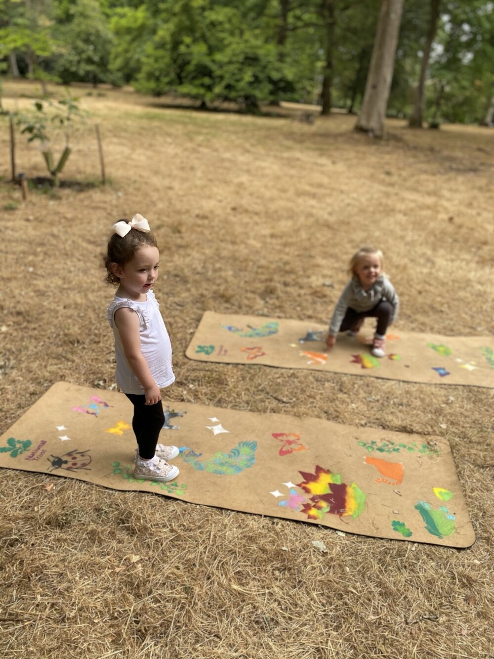 Children playing on illustrated mats in an outdoor space