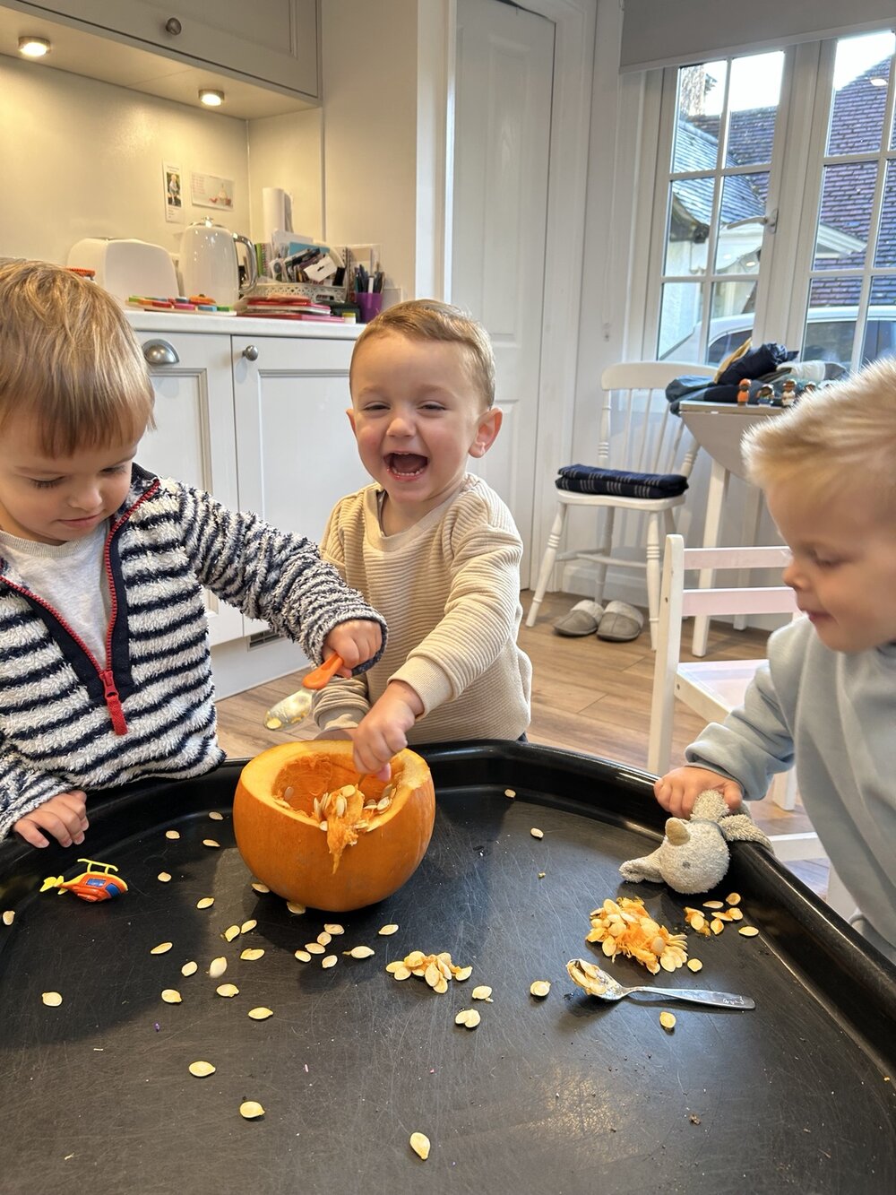 Children scooping seeds from a pumpkin together
