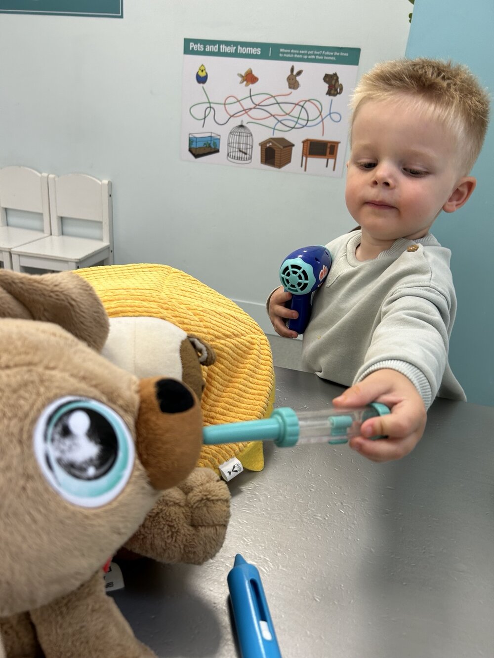 A child caring for a toy animal using pretend veterinary equipment